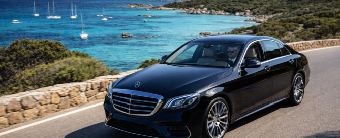 NCC Costa Smeralda lusso con auto premium e conducente su strada panoramica