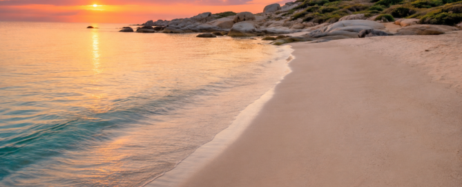 Sunrise over a deserted Mediterrenean beach with clear water, pale, sand and granite rocks